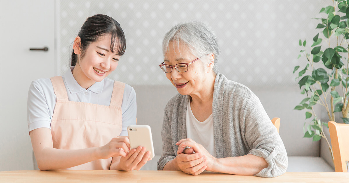 スタッフがシニアのスマホをサポートしている様子